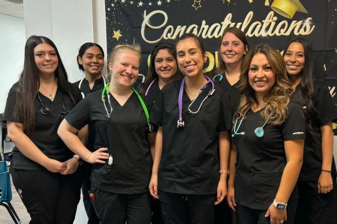 graduates posing with congratulatory sign graduates posing with congratulatory sign